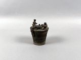 miniature figurine of a man in a bucket on a white surface