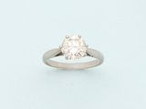 a diamond ring on a white surface with a light blue background