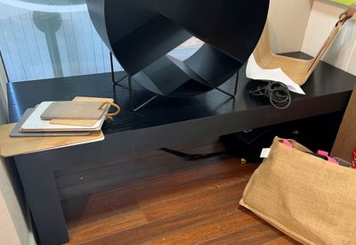 a black table with a lamp and a bag on it