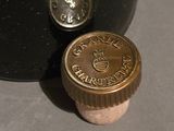 a bottle of wine that is next to a cork stopper