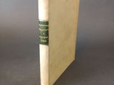 an old book with a green ribbon on the cover