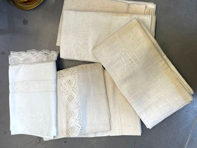 four white linen napkins with lace trim and a glass of wine