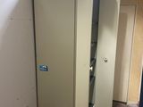 a refrigerator in the corner of a room with a chalk board on the floor