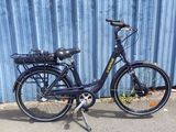 un vélo noir garé devant un mur bleu