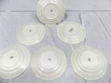 six white plates with blue flowers on them sitting on a table