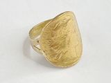 gros plan d'une bague en or sur une surface blanche