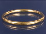 un gros plan d'une bague en or sur une surface bleue
