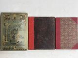 trois livres sont alignés sur une surface blanche