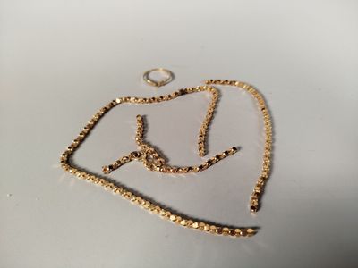une photo d'un collier en or posé sur une surface blanche