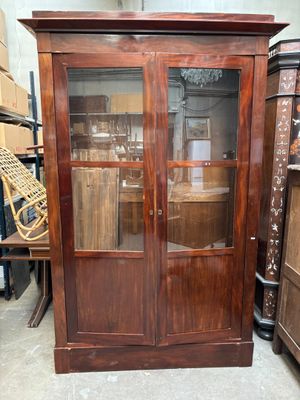 un meuble en bois avec une porte en verre dans une pièce