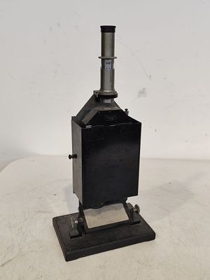 un vieux poêle en métal noir posé sur une table blanche
