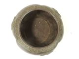 a small bronze bowl with a decorative design on it