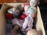 une boîte en carton contenant une poupée, posée par terre