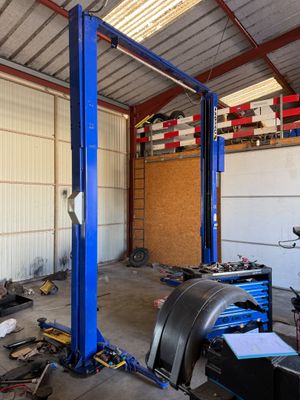 une voiture sur laquelle travaille un mécanicien dans un garage