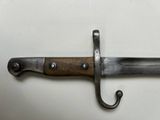 a close up of a knife hanging on a hook on a wall