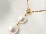 un pendentif composé d'une perle blanche et de diamants, monté sur une chaîne en or