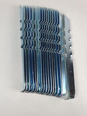 un gros plan sur un ensemble de lames métalliques posées sur une surface blanche