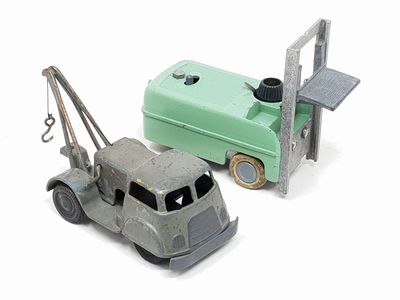 two toy trucks that are next to each other on a white surface