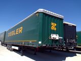 a green train car that is parked on the side of the road