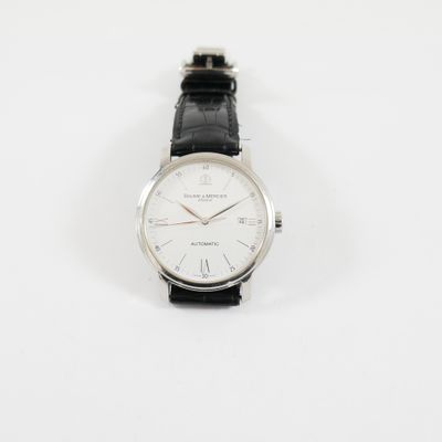 un gros plan d'une montre sur une surface blanche avec un fond blanc