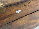 an old wooden box with a tag on it sitting on a table