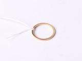 gros plan d'une bague en or sur une surface blanche
