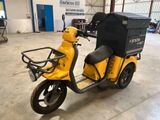 un scooter jaune avec un coffre noir à l'arrière
