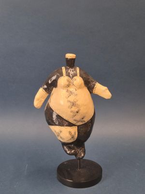 figurine of a fat man on a black base on a blue background