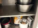 a stainless steel shelf with bowls and pans on it