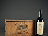 a bottle of wine sitting next to a wooden box on a table