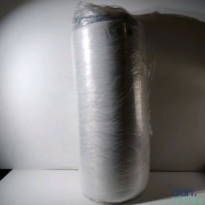 un gros rouleau de papier d'aluminium emballé dans du film plastique, posé sur une table