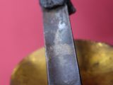 a close up of a knife on top of a brass plate