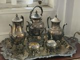 a silver tray with a silver tea set on top of it
