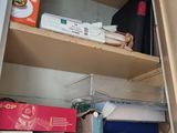 a closet with a lot of boxes and papers on the shelves