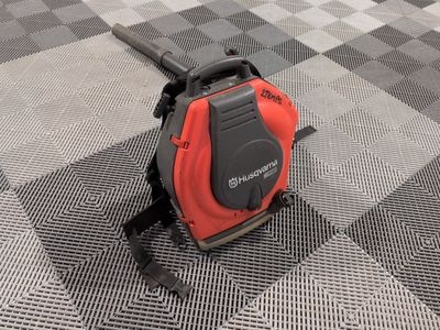 a red and black blower sitting on top of a checkered floor