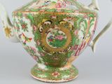 a green and white vase with flowers on it
