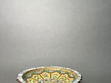 a yellow and green bowl sitting on top of a table