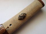 a wooden pen holder with a metal lion head on it