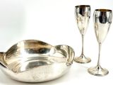 deux verres à vin et un bol en argent posés sur une table