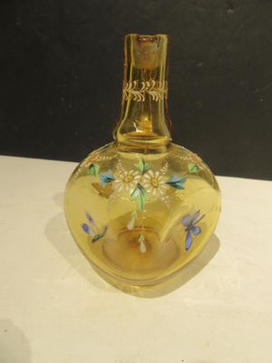 a yellow glass bottle with a candle inside of it