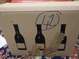 a cardboard box with three bottles of wine in it