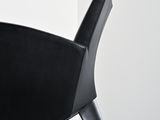 a black chair with a black seat in a white room
