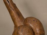 une sculpture en bois représentant un escargot posée sur une table en verre