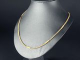 un collier à chaîne en or posé sur un présentoir pour mannequin
