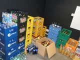 many boxes of sodas and bottles of soda in a room