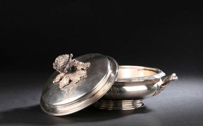 un plat ancien en argent avec un couvercle, posé sur une table