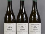 three bottles of wine are lined up on a table