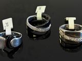 three different rings are displayed on a black surface with tags