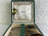 un coffret vert contenant de l'argenterie sur une table