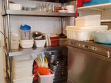 une étagère en acier inoxydable dans une cuisine, avec de la vaisselle et des casseroles